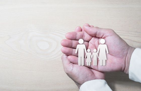 Famille en papier dans le creux d'une main